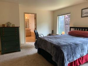 a bedroom with a bed and a dresser and a window at Cedar River one bedroom in a four bedroom house in Renton
