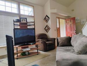 a living room with a couch and a television at Cedar River one bedroom in a four bedroom house in Renton