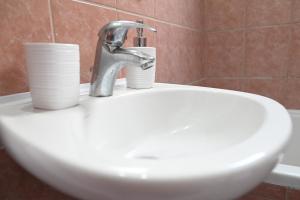 a bathroom sink with two cups and a faucet at Garden Bliss 1 Alexandroupolis in Alexandroupoli +17 photos