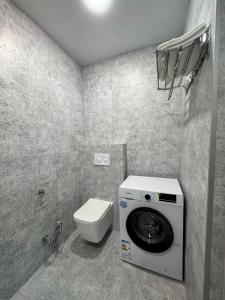 a bathroom with a washing machine and a toilet at Meloso in Kobuleti