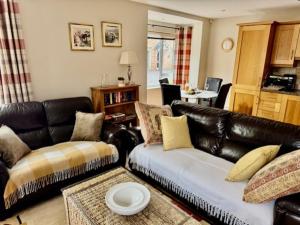 a living room with a leather couch and a table at The Sidings in Enniskillen