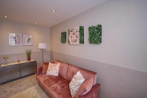 a living room with a brown leather couch and some plants at L'octroi de Loches in Loches