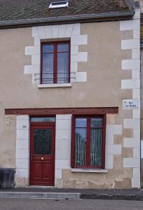 a building with two red doors and two windows at L'octroi de Loches in Loches