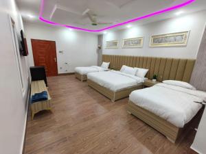 锡卡都Nestopia Hotel - Skardu的酒店客房配有两张床和紫色灯