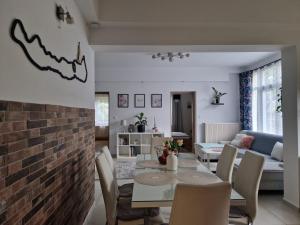 a living room with a brick wall and a table and chairs at Angéla Ház in Balatonberény