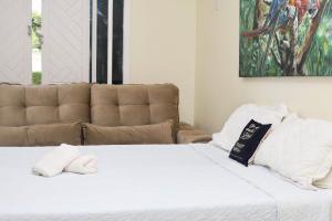 un letto bianco con divano in camera di Beach house in the heart of Atalaia - Casa de praia no coração de Atalaia ad Aracaju Altre 100 foto