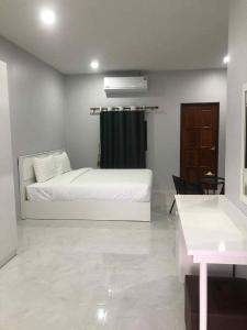 a bedroom with a white bed and a black curtain at Borrii House โบ ลี่ เฮาท์ in Layan Beach