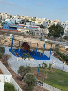 a playground in a park with blue equipment at Nof Yonna - Sea & Sky in Jisr ez Zarqā