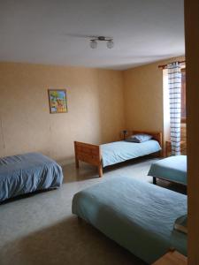 a bedroom with two beds and a window at La Ferme 3 in Arinthod