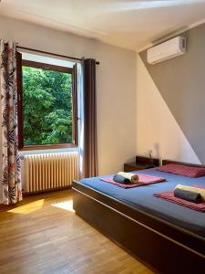 a bedroom with two beds and a large window at Villa Angelina in Cannero Riviera