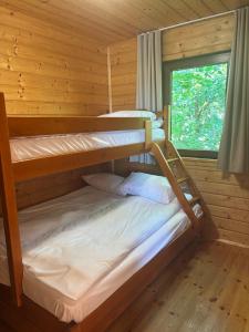 two bunk beds in a cabin with a window at Domki Bałtyku Szept in Darłowo +39 photos