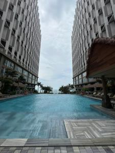 a large swimming pool in the middle of two buildings at Apec Mandala wyndham Apartment - APEC Mui Ne in Mui Ne