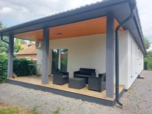 a pavilion with chairs on a wooden deck at Forest Apartman in Nyíregyháza