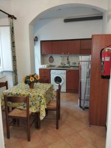 a kitchen with a table and a kitchen with a washing machine at Casetta vacanze a due passi dal mare in Santa Margherita Ligure
