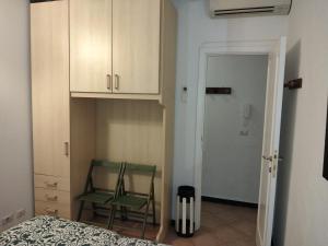 a bedroom with a green chair and a cabinet at Casetta vacanze a due passi dal mare in Santa Margherita Ligure