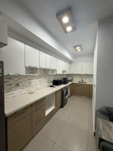 a large kitchen with white cabinets and a dishwasher at Zafero marassi FOR FAMILIES ONLY NO COUPLE- weekend without sea in El Alamein +6 photos