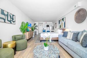 默特尔比奇Breathtaking Luxury Beach Escape with Oceanfront Views-Landmark 731的客厅里有一张沙发、几把椅子和一张床