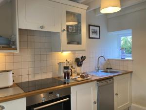 a kitchen with white cabinets and a sink at 1 Penygroes in Penmachno