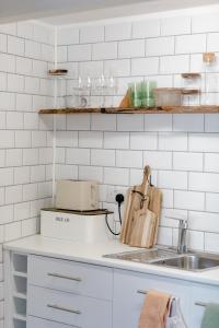 a kitchen with a sink and white tiled walls at Flat in Arundel in Arundel
