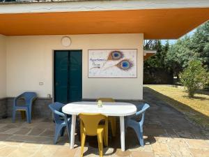 Una mesa blanca y sillas en un patio. en Appartamento Pavone, en Viterbo