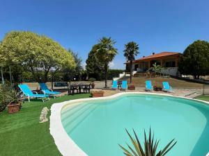 a swimming pool in a yard with chairs and a table at Appartamento Pavone in Viterbo