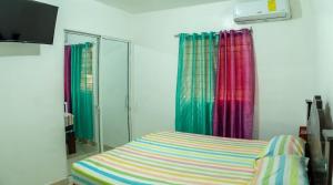 a bedroom with colorful curtains and a bed with a mirror at Comodo apartamento en el centro de la ciudad in Santiago de los Caballeros