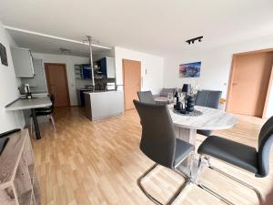 un soggiorno e una cucina con tavolo e sedie di Gartenloge Messkirch a Messkirch
