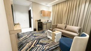 a living room with a couch and a kitchen at شقق ملامح المدينة in Al Madinah
