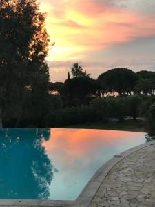 a swimming pool with a sunset in the background at La Rose des Sables suite 5 étoiles in Les Issambres
