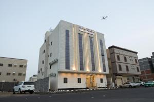 a tall building with cars parked in front of it at شقق ملامح المدينة in Al Madinah
