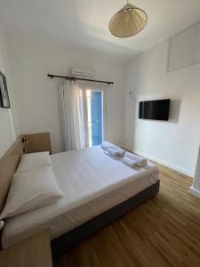 een groot bed in een kamer met een raam bij Meraki Inn in Mirina