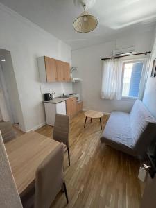 a small living room with a table and a kitchen at Meraki Inn in Mirina