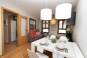 a kitchen and living room with a white table and chairs at Casa de La Laguna by BeValle in Panticosa