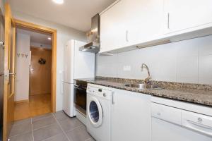a kitchen with a sink and a washing machine at Casa de La Laguna by BeValle in Panticosa