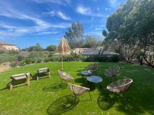 a group of chairs and tables on a lawn at La Rose des Sables suite 5 étoiles villa Côté Cœur in Les Issambres