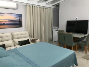 a bedroom with a bed and a desk and a television at ESTUDIO PANORAMiCO in Florianópolis