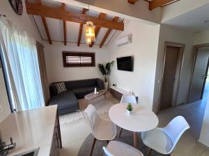 a living room with a couch and a table and chairs at Kalliopi Luxury Apartments in Kalliópi