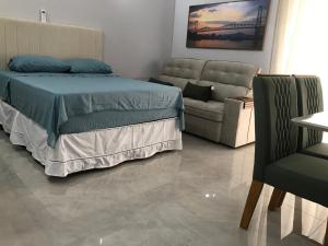 a bedroom with a bed and a couch at ESTUDIO PANORAMiCO in Florianópolis