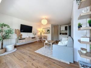 a living room with a couch and a tv at Stella, Studio Beige et Plage in Cucq +7 photos