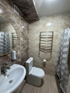 a bathroom with a toilet and a sink and a mirror at Hotel Racu Family in Komrat