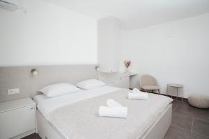 a bedroom with a bed with two white towels on it at Villa Apartments Blanco - Near Airport Banja Luka in Laktaši