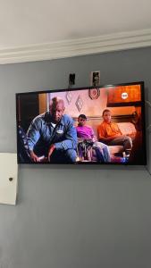 une télévision à écran plat avec trois hommes assis sur un canapé dans l'établissement Hotel novo bis, à São Paulo 23 autres photos