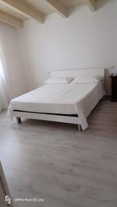 a bed in a white room with a large mattress at La casa di Erica in Sestu