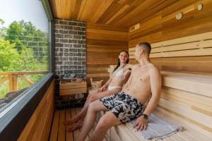 a man and a woman sitting in a sauna at The Lodge Transylvania in Bran