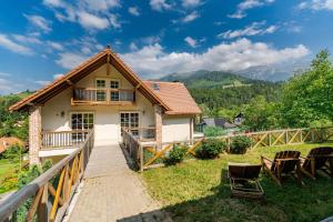 a house with a deck and chairs in front of it at The Lodge Transylvania in Bran +60 photos