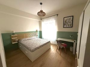 a bedroom with a bed and a desk and a window at Il Bricoccolo in Loreto