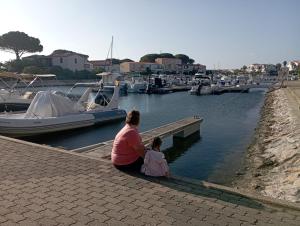 a woman and a little girl sitting on a dock at Marina St Cyprien in La Celle-sous-Gouzon