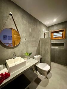 a bathroom with a sink and a toilet and a mirror at Kza da Paty Preá dEla in Prea +40 photos