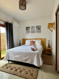 a bedroom with a white bed and a window at Kza da Paty Preá dEla in Prea