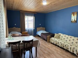 a room with a couch and a table and a bed at guest house merab in Borjomi